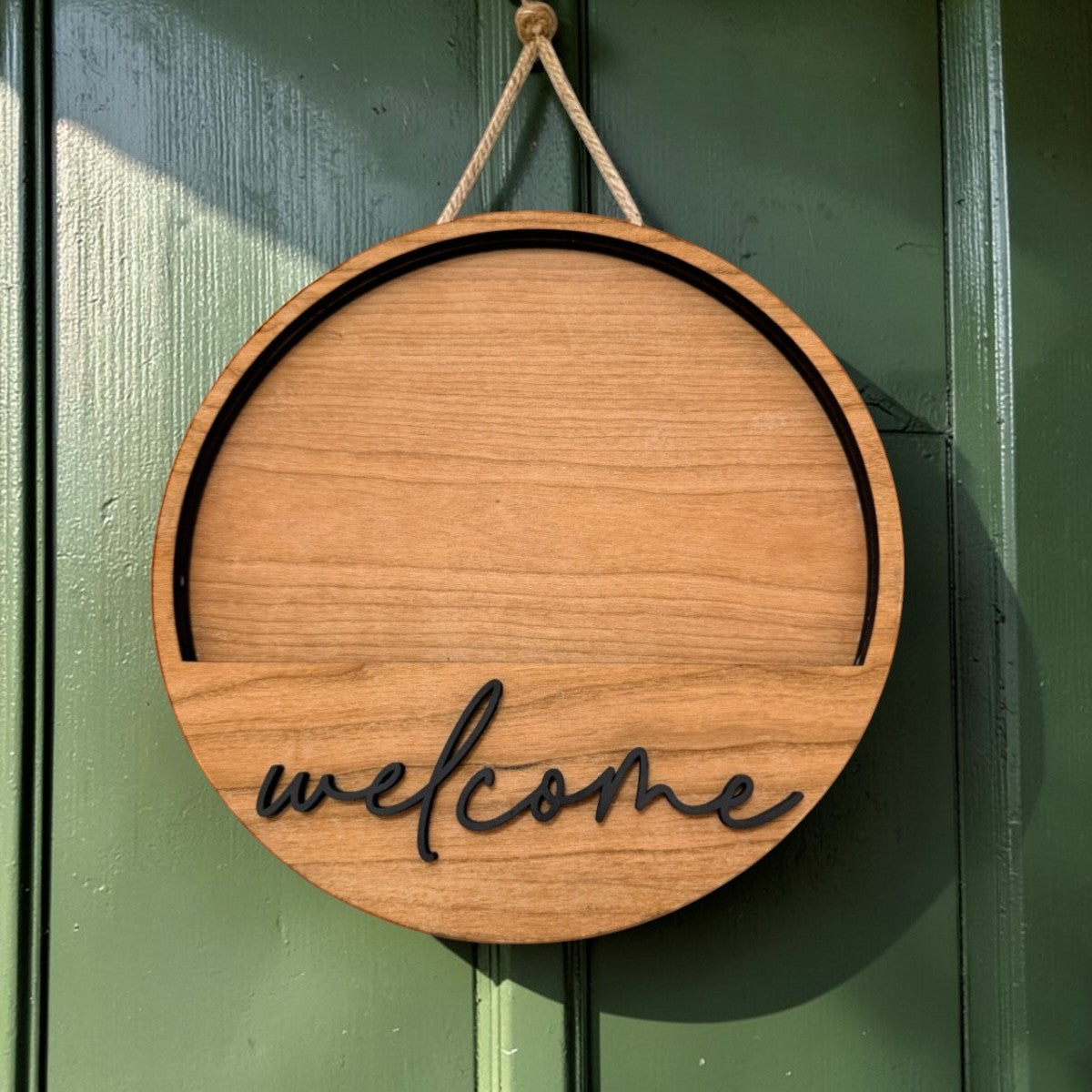 C2 Creative Crafts round wooden door hanger with black "welcome" text and black trim.
